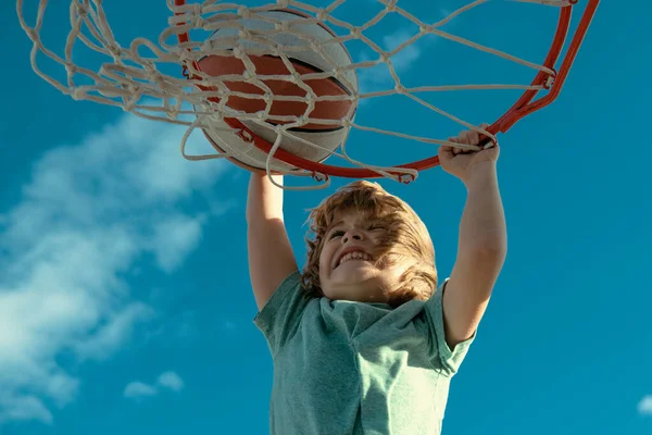 stock image Kid basketball player makes slam dunk. Active kids enjoying outdoor game with basketball