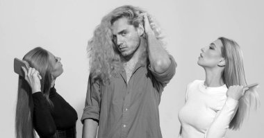 Arka planda saç tarayan çeşitli kadın ve erkek grupları. Çekici, neşeli, seksi, modaya uygun, saç tarayan grup modelleri. Çekici erkek ve kadının saçını tarayan kuaför.