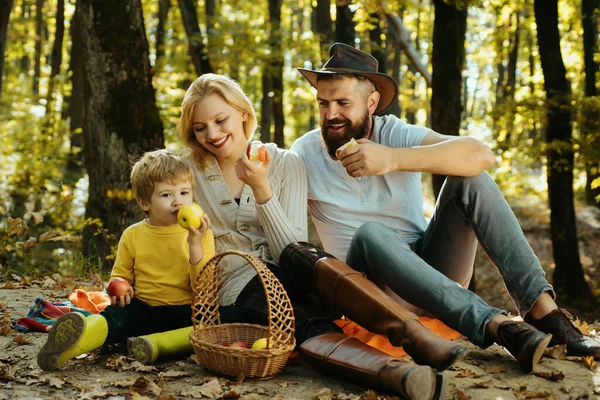 Picnic in nature. Meaning of happy family. United with nature. Family day concept. Happy family with kid boy relaxing while hiking in forest. Mother father and small son picnic. Country style family.