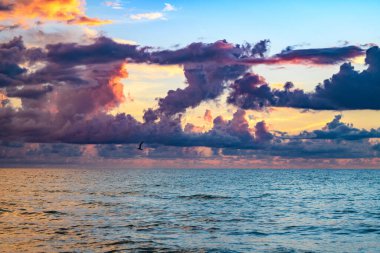 Gün batımı deniz manzarası. Gökyüzünde gün batımı ve renkli bulutlar. Sakin dalgalarla renkli sahil gündoğumu. Doğa deniz göğü. Mavi gökyüzüne ve denize karşı farklı renkte bulutlarla gün doğumu