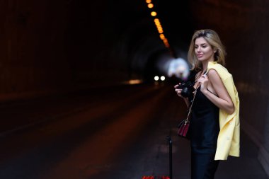 Traveller, fashion tourist. Traveler tourist woman in fashion clothes with suitcase. Traveler tourist girl in trendy dress with suitcase. Female model travel abroad weekends. Journey concept