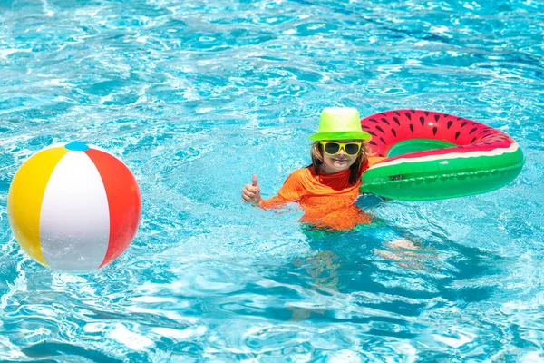 夏の日にプールでカラフルな水泳リングで遊ぶ幸せな子供 子供の水の休暇 子供たちは熱帯のリゾートで遊ぶ 子供は夏のプールの水で泳ぐ — ストック写真