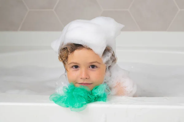孩子头上的泡沫 在孩子头上涂肥皂 洗澡时带着泡泡的小男孩 可爱的孩子洗澡了 躺在一个用肥皂和洗发水泡的白色浴缸里 — 图库照片