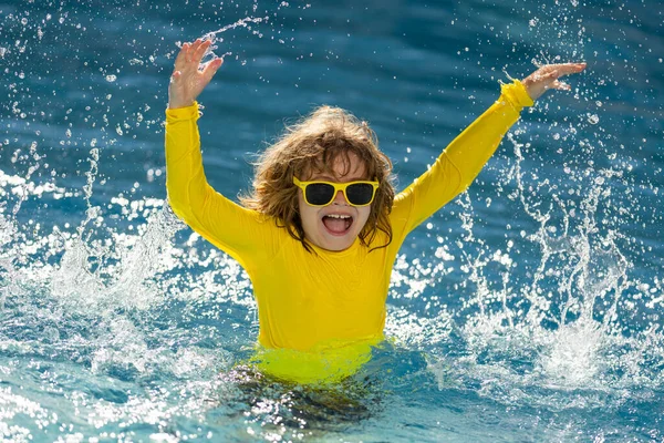 孩子们在夏天的游泳池里飞溅 孩子在游泳池里泼水 兴奋的小男孩跳进了游泳池 水很好玩 小孩跳进游泳池 飞溅在船舷上的小孩 — 图库照片