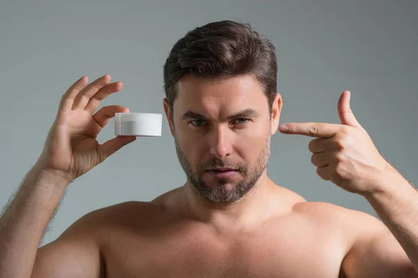 American man applying face cream on wrinkle. Morning beauty routine. Man with wrinkle skin. Anti-aging and wrinkle cream. Concept of male beauty. Close up face of man applying cream to wrinkle skin