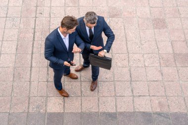 İş ortaklarının en iyi görüşü açık havada sohbet etmeleridir. Takım elbiseli iki yakışıklı iş adamı şehir geçmişine karşı yürütülen bir projeyi tartışıyor. Yeni projeler ya da girişimler. İşbirliği kavramı