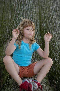 Tatlı çocuk meditasyonu. Özgürlük kavramı. Huzurlu çocuklar meditasyon yapıyor. Yoga yapan çocuk