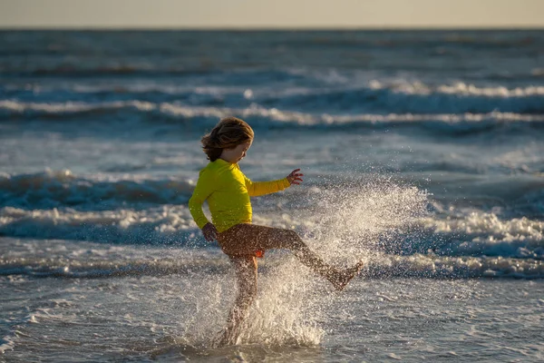 レジャースポーツ活動中に海沿いを走るアクティブな小さな子供 スポーツ少年は本質的に走っています 子供は海辺を走る ビーチで走っている子供たち 夏休みだ 幸せな子供時代 — ストック写真