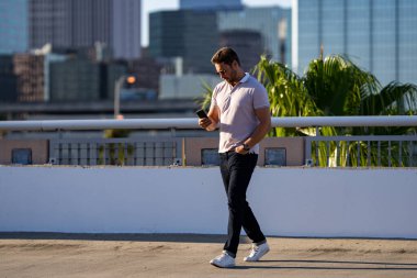 Şehir merkezinde telefonda sohbet eden sıradan yakışıklı bir adam. Havalı gözlükler takan ve dışarıda polo oynayan iyi giyimli bir adam. Telefon kullanan bir iş adamı. Şehirdeki erkek telefon görüşmeleri