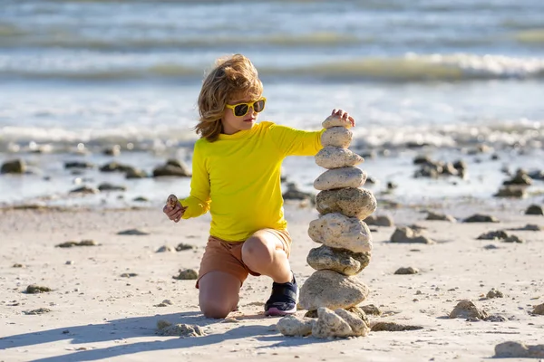 夏天的孩子冥想小孩在海滩上玩石头 孩子们在海滩 休息和海滨度假时与金字塔般的石头玩耍 — 图库照片