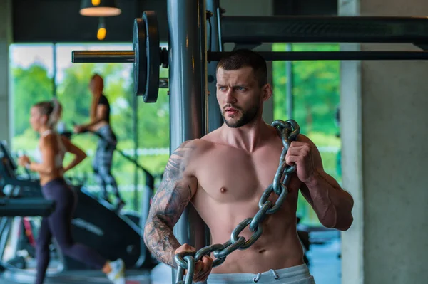 やる気のある男性アスリートは ジムで体重計チェーン ボディビルディングワークアウトで運動をします 強い筋肉質の人に適性の試しがある スポーツと健康的なライフスタイルの概念 鎖を持った筋肉質の男 — ストック写真