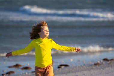 Yaz tatilinde deniz kıyısında koşan bir çocuk. Yaz tatili. Yaz çocukları hafta sonu. Deniz suyundaki çocuk. Yaz eğlencesi. Çocuk denizde yaz tatilinin tadını çıkarıyor. Denizdeki yaz çocuğu