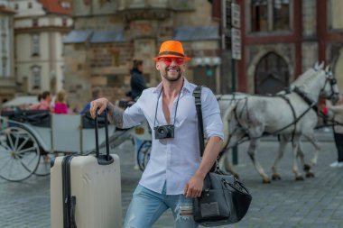 Tatilde bir turist. Bagajı olan bir adam tatile çıkmaya hazır.