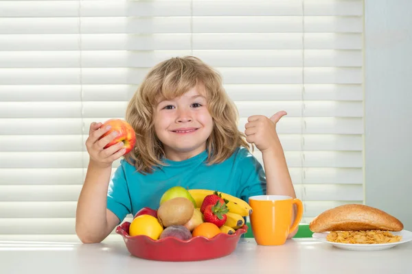 子供がリンゴを食べる 学校の前に朝食を食べる子供 小さな十代の子供の肖像画自宅のキッチンで机に座っておいしい栄養価の高い朝食を持っています — ストック写真