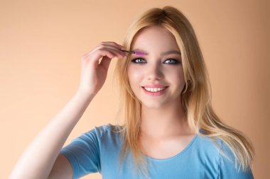 Koyu kaşlı güzel bir kadın kaş fırçası tutuyor. Kaş kaplaması. Güzellik prosedürlerini uygula. Kaş ve kaş çizgisi, kaş çizgisi.