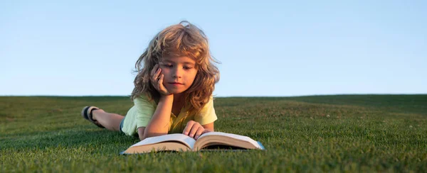Söt Pojke Läser Bok Utomhus Grönt Gräs Fält Smart Barnbok — Stockfoto