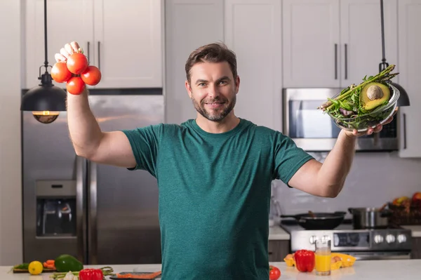 若い男は台所でビーガン健康サラダを調理 現代のキッチンテーブルチョップ野菜で千年の男は 夕食や昼食のための新鮮な野菜サラダを準備します 健康的な食事 ベジタリアンの概念 — ストック写真