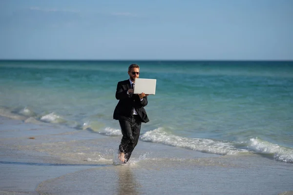 Excited businessman in wet suit run in sea. Funny business man, crazy comic business concept. Remote online working. Crazy summer business. Fun business lifestyle. Funny freelance businessman