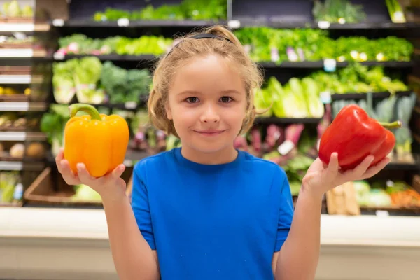 食料品店で野菜やピーマンを持つ子供 子供は店内で新鮮な野菜や果物を選んでいます 食料品スーパーで食べ物を買う子供 食料品店での購入 — ストック写真