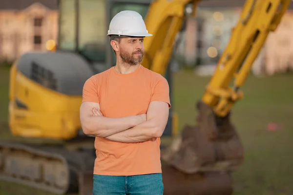Worker man, small business owner. Construction worker with hardhat helmet on construction site. Construction engineer worker in builder uniform with excavation digging. Worker construction