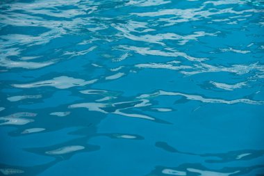 Yüzme havuzunda güneş yansımalı dalgalı su. Dalgalı su arkaplanı