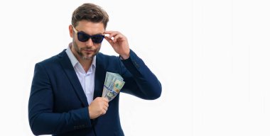 Takım elbiseli ve parası olan bir adam. Dolar banknotları. Amerikan banknotlarını tutan adamın portresi. Dolar, kredi, internet bankacılığı. Zengin adam dolar banknotlarını, banka kredilerini, mali tasarrufları gösteriyor