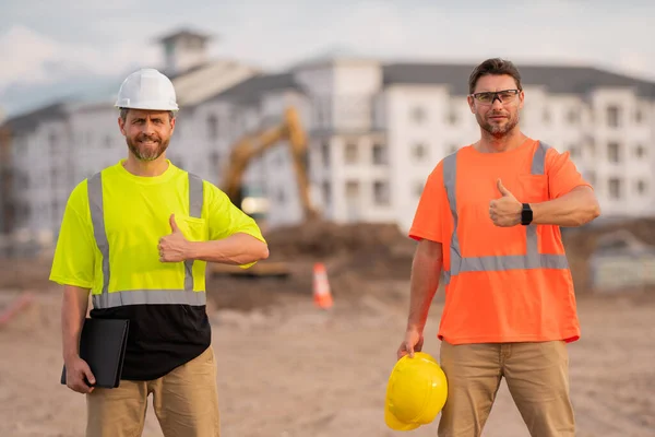 建筑工地有两名戴安全帽的建筑工人 身穿建筑工人制服的建筑工人 两个建筑商准备建造新房子 建筑工地上戴硬帽的工人 — 图库照片