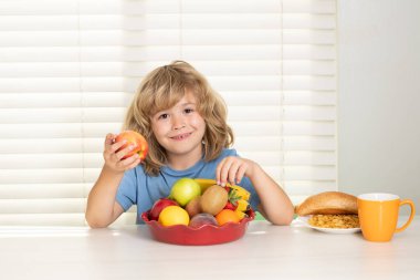 Kid eating apple. Child eats organic food. Healthy vegetables with vitamins. Proper kids nutrition concept