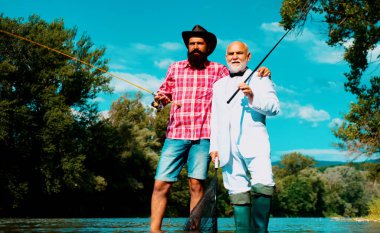 Men fishing. Fishing anglers in river water. Old and young fisherman