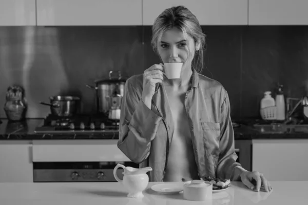 無修正パジャマの官能的な女の子はコーヒーをお楽しみください 朝はキッチンに座ってコーヒーを飲んでいるセクシー女性 官能的な主婦 — ストック写真