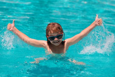 Su sıçrat. Çocuk yazın havuzda dinlenir, suya su sıçrar, boş zamanlarında el kaldırır.