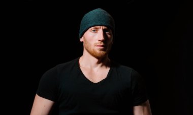 Siyah üzerine yakışıklı bir adamın portresi. Kendine güvenen ve zalim bir adam.