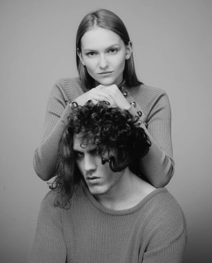 Birbirine aşık çiftler, birbirine sarılıp kucaklaşan şehvetli aşıklar. Genç bir çiftin portresi. Stüdyoda bej arka planda moda bir çift. Modaya uygun bir çift.