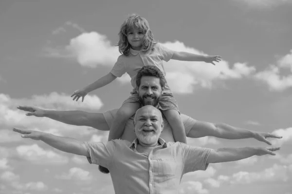 家庭会议 父亲和一个男孩看到祖父举起双手或张开双臂在天空中飞翔 — 图库照片