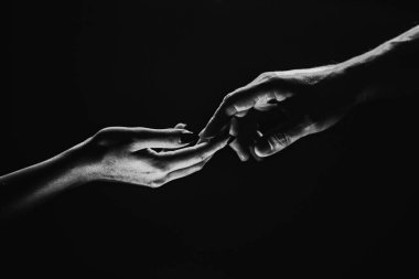 Two hands reaching toward. Tenderness, tendet touch hands in black background. Romantic touch with fingers, love. Hand creation of adam