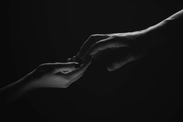Two hands. Helping hand to a friend. Rescue or helping gesture of hands. Concept of salvation. Hands of two people at the time of rescue, help. Isolated on black background. Tenderness, tendet touch