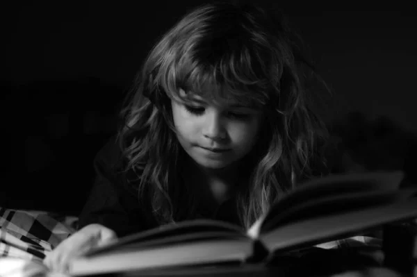 孩子在睡觉前在床上看书 小男孩躺在床上看书 睡前故事 孩子们童话 — 图库照片