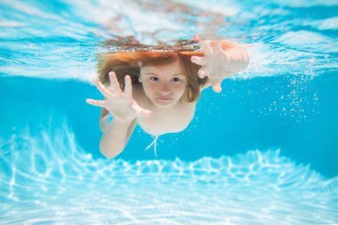 Sualtı çocuğu havuzda yüzer, sağlıklı çocuklar yüzer ve suyun altında eğlenir. Çocuklar tatil ve tatil konsepti. Yaz çocukları