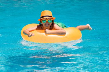 Tatiller ve çocuklarla yaz tatili. Çocuk 7, 8, 9 yaşlarında yüzme havuzunda yüzüyor. Çocuklar yazlık komik surat