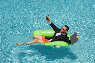 Yaz işi. Yüzme havuzunda serbest çalışan. Yüzme havuzunda dalgıç kıyafetli bir iş adamı. Çılgın iş tatili. Yüzme havuzunda komik çılgın iş adamı kıyafeti. İş adamı için sıcak yaz