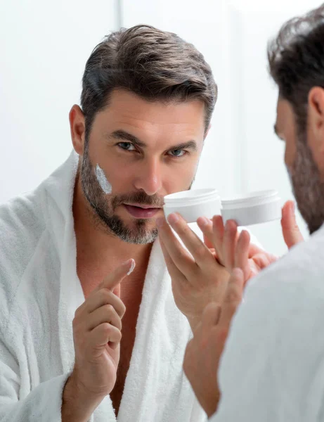 Beauty male face cream. Beauty routine. Beauty man with perfect skin. Anti-aging and wrinkle cream. Concept of male beauty. Close-up face of man applying cream to skin. Skincare cosmetics concept
