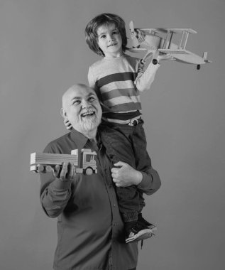 Büyükbaba ve torunun oyuncaklarla oynadığı portre. Aile İlişkisi Büyükbaba ve Torun. Erkek Aile Kavramı. Pozitif çocuk, büyükbaba ve torun mavi arka planda izole edilmiş.