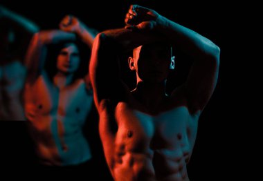 Geylerin kaslı vücudu. Kas modelleri koyu renk arka planda genç erkekler. Kaslı, çıplak vücutlu, güçlü, vahşi adamların moda portresi. Seksi çıplak gövde, karın kası.