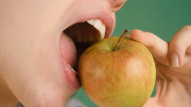 Diş konsepti. Sağlıklı beyaz dişler elmayla kapanır.