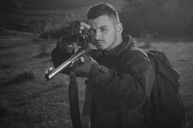 Avcı tüfeklerinin kalibreleri. Güzel Günbatımında Tüfek Avcısı Silueti. Sonbahar. Dürbünlü Güçlü Tüfekli Avcı Hayvanları İzliyor