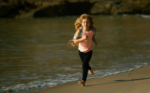 子供はビーチで走ってる 幸せな子供は夏休みに海で走ります 訓練中のアスリートはほとんどいない ランナーの運動 子供のジョギング — ストック写真