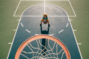 Çocuk bahçesinde basketbol oynayan çocuğun üzerinden açılı görüş