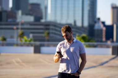 Şehir merkezinde telefonda sohbet eden sıradan yakışıklı bir adam. Havalı gözlükler takan ve dışarıda polo oynayan iyi giyimli bir adam. Telefon kullanan bir iş adamı. Şehirdeki erkek telefon görüşmeleri