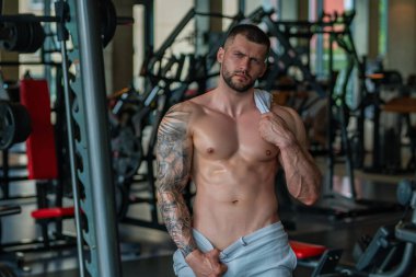Seksi erkek vücudu. Kaslı adamlar ağırlık kaldırıyor. Güçlü erkek model spor salonunda egzersiz yapıyor. Dambıl kaldıran adam, güçlü atletik formda adam.