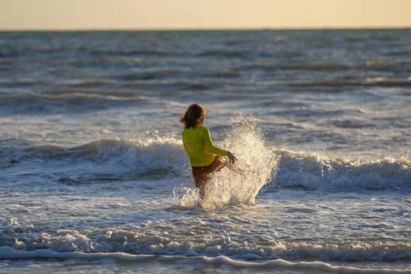 夏休みに海の水の中に走っている子供 海沿いを走る子供の少年 夏のビーチで子供 子供は海の水でレースを実行します 子供は海の水に沿って走る 海の夏休みの子供 — ストック写真